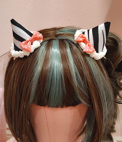 Zebra patterned devil horn hair clips with decoden cream and pink bows.