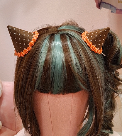 Brown devil horn hair clip accessory with white polkadots and orange decoden cream.