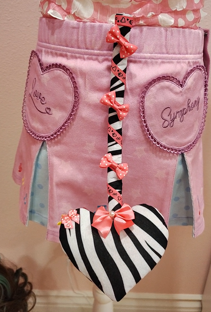 Zebra patterned devil tail accessory with heart tip, pink ribbons and bows.