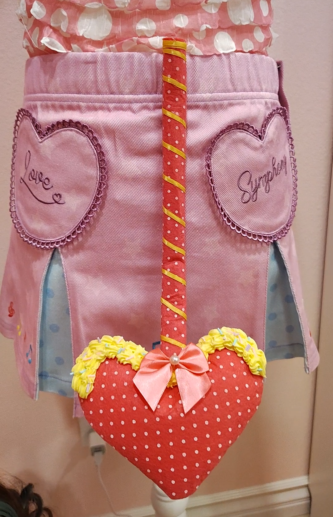 Rose pink and yellow devil tail accessory with white polkadots, yellow ribbon, and yellow decoden cream.