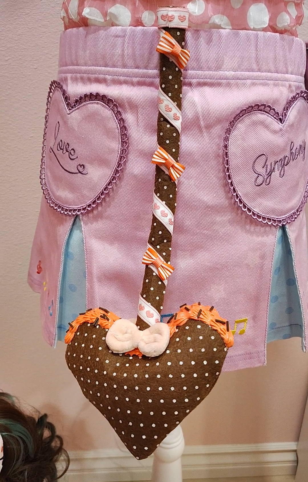 Brown devil tail with heart prong, white polkadots, wrapped in a multicolored white and orange ribbon detail with decoden cream