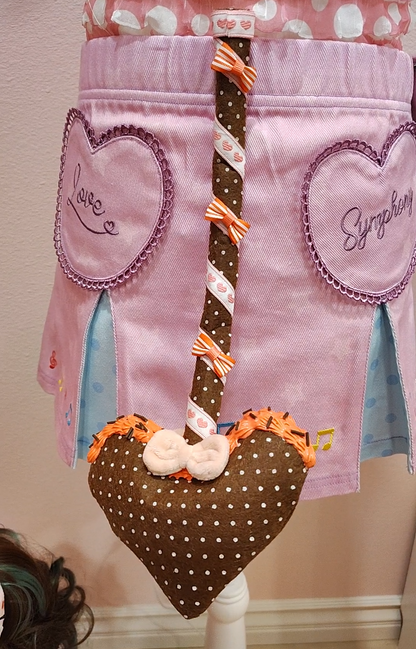 Brown devil tail with heart prong, white polkadots, wrapped in a multicolored white and orange ribbon detail with decoden cream