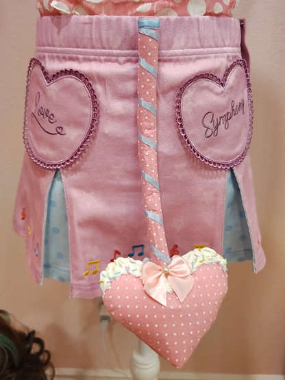Pink devil tail accessory with white polkadots, baby blue ribbon, white decoden cream with sprinkles, pink bow, and a heart prong.