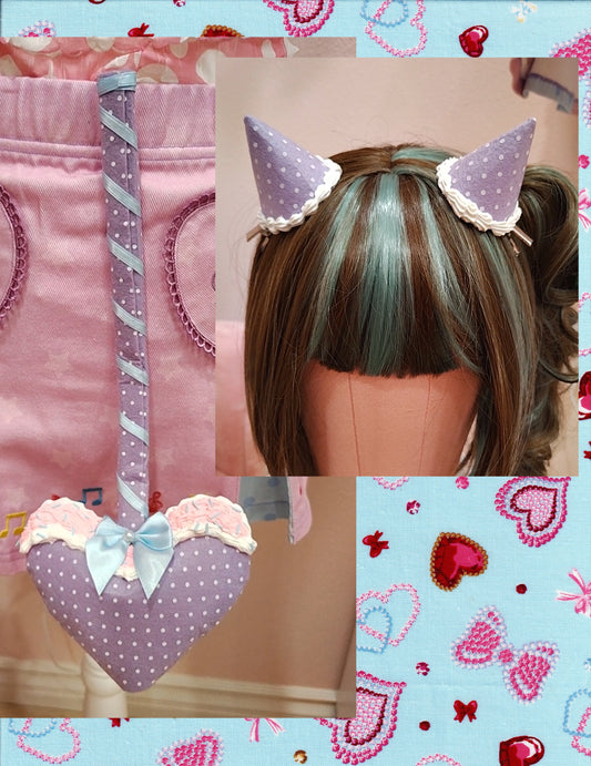 Collage of a purple devil tail with white polka dots and a heart prong with matching devil horn hair clips, on a decorative background